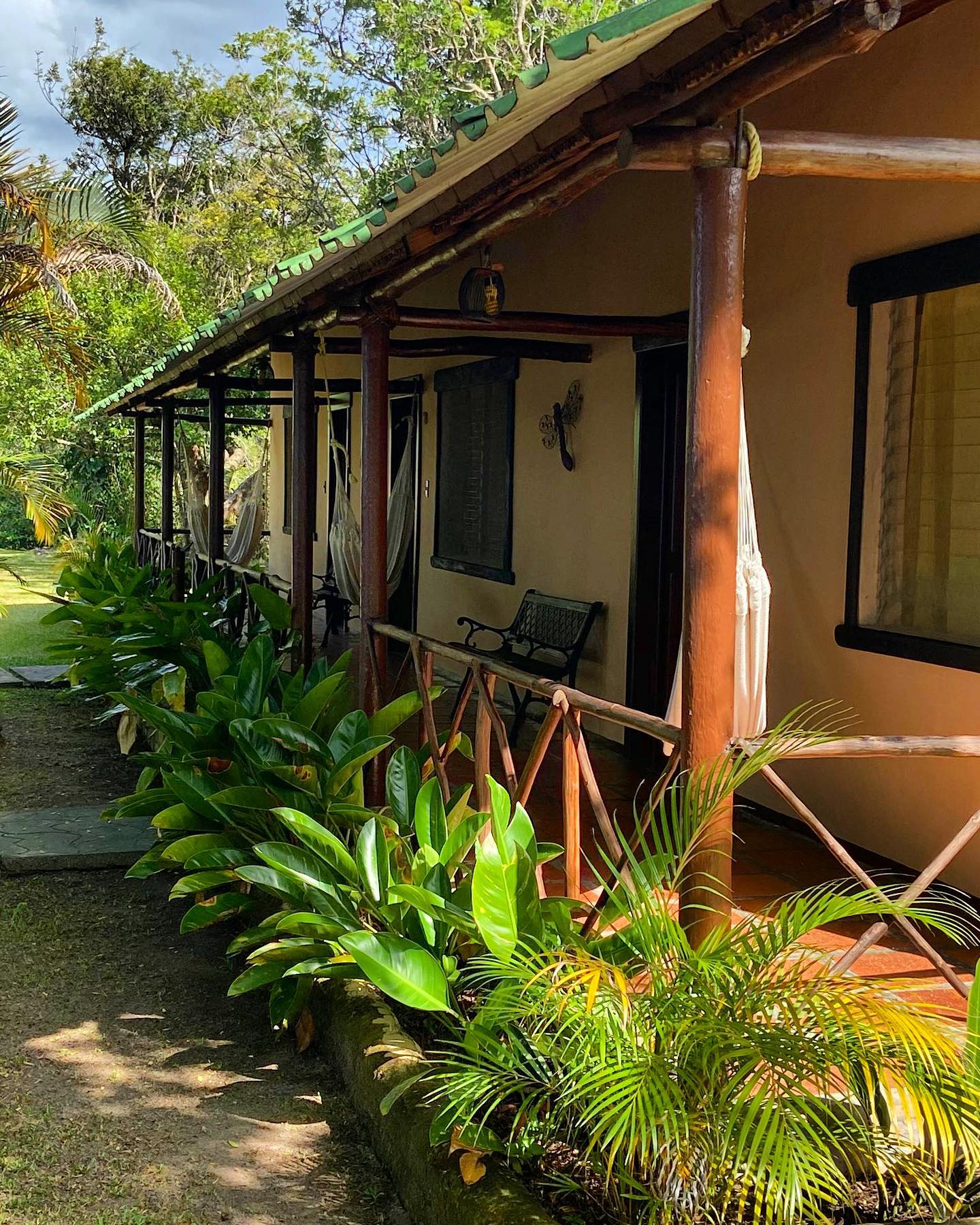 Corredor de las habitaciones de Ucaima, con hamacas y un jardín tropical.