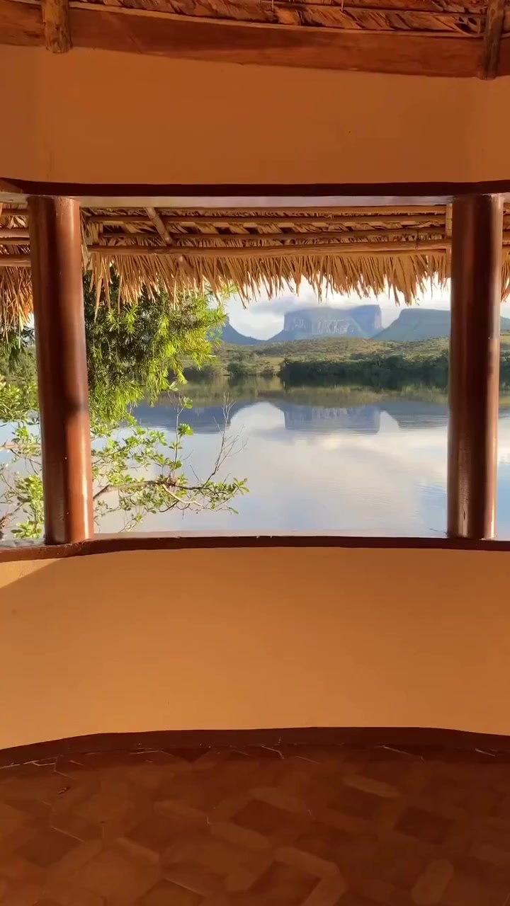 Vista desde una habitación hacia el agua y los tepuyes reflejados en Canaima.